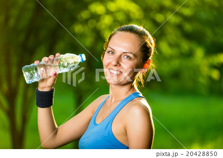 Young woman drinking water after fitness exercise 20428850