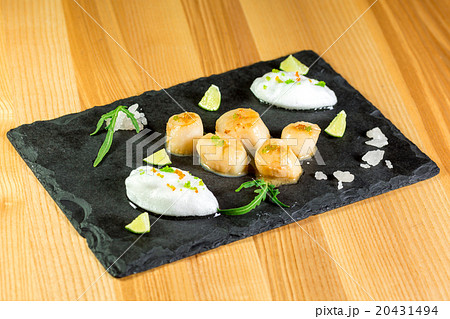 Studio close up of seared scallops, garnished  20431494