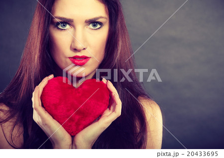 Woman holds red heart love symbol Woman holds red heart love symbol 20433695