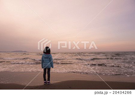 夕暮れの海岸と子ども 佇む の写真素材