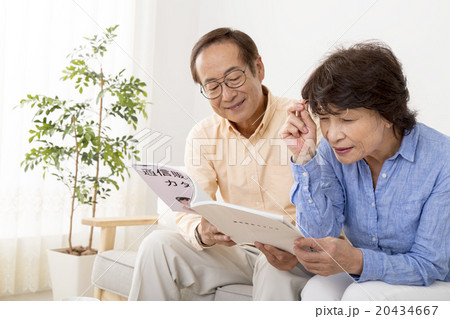 通販カタログを見るシニア夫婦 20434667