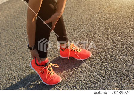 woman runner hold her injured leg on road. woman runner hold her injured leg on road. 20439920