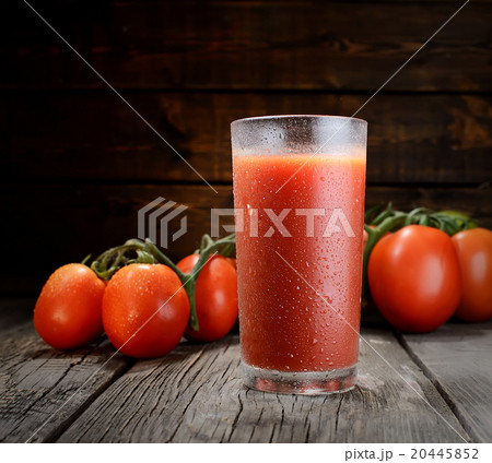 Glass of tomato juice on wooden table, on wood pla 20445852