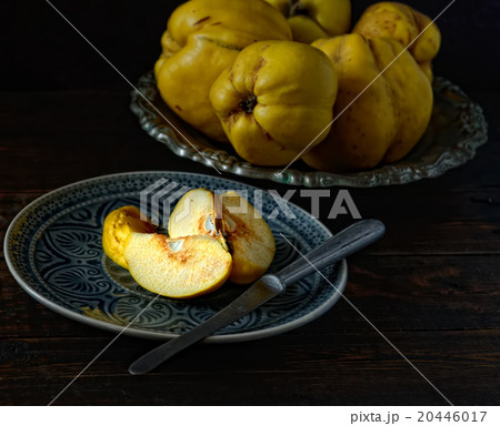 cut fruit quince on a plate, a knife on a wooden b 20446017