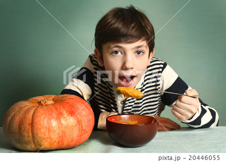 boy with big orange pumpkin eat mash cream soup 20446055