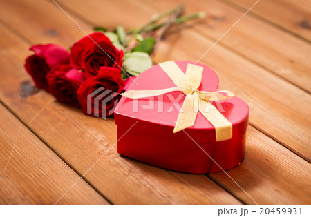 close up of heart shaped gift box and red roses 20459931