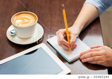close up of woman writing to notebook with pencil close up of woman writing to notebook with pencil 20460384