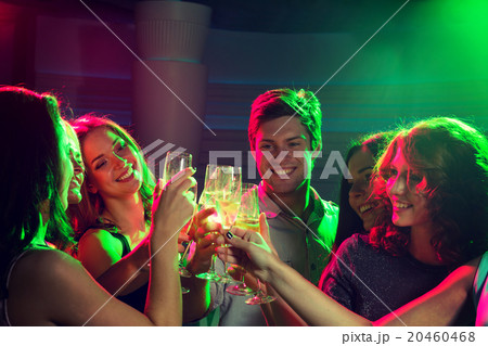 smiling friends with glasses of champagne in club smiling friends with glasses of champagne in club 20460468