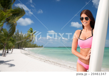 smiling young woman with surfboard on beach 20461347