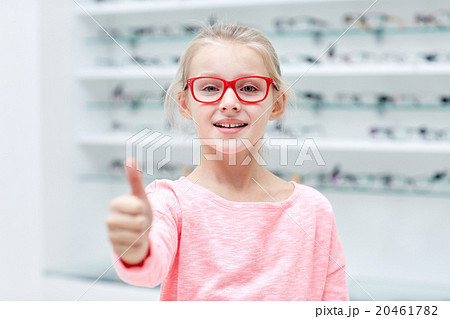 girl in glasses at optics store showing thumbs up 20461782