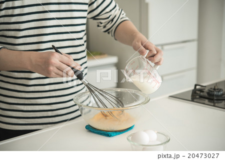 キッチンで泡立て器を使って材料を混ぜる人物 キッチンで泡立て器を使って材料を混ぜる人物 20473027