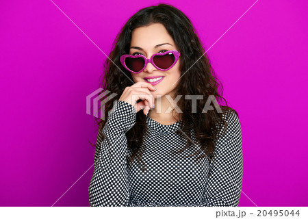 beautiful girl glamour portrait on magenta in heart shape sunglasses, long curly hair beautiful girl glamour portrait on magenta in heart shape sunglasses, long curly hair 20495044
