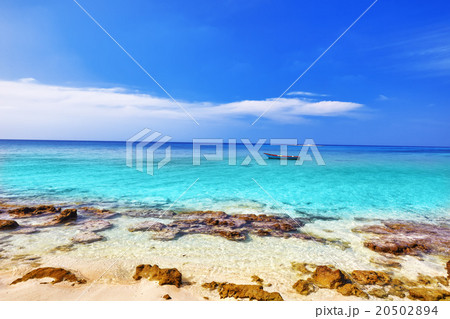 Shoreline of a tropical island with boat 20502894