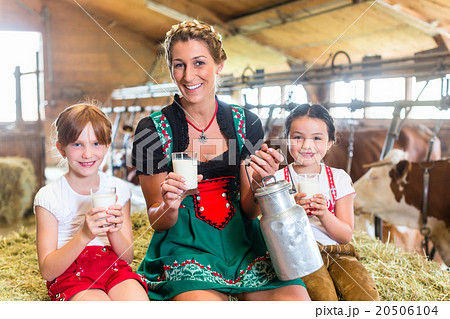 Bavaria family drinking milk in cow barn 20506104
