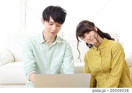 引越しの準備をいてパソコンを開く若い男女 20509338