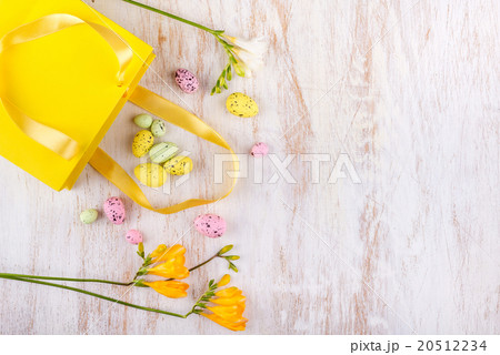 easter eggs and flowers over white wooden table 20512234