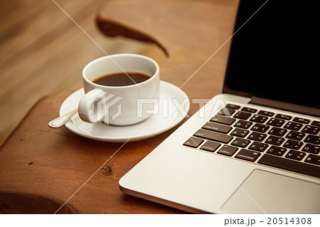 coffee in a white cup on a table with a computer 20514308