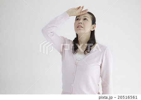 40代女性 不安 焦り 空を見上げるポーズの写真素材