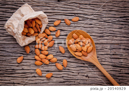 Almonds in brown paper bag and white bowl. 20540929
