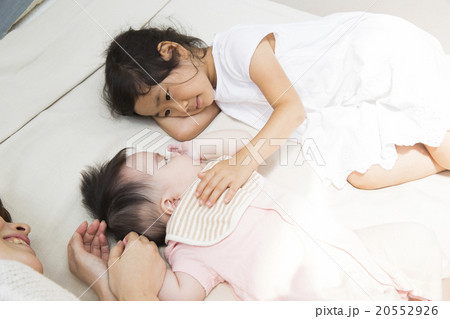 寝転ぶお母さんと赤ちゃんと女の子 寝転ぶお母さんと赤ちゃんと女の子 20552926