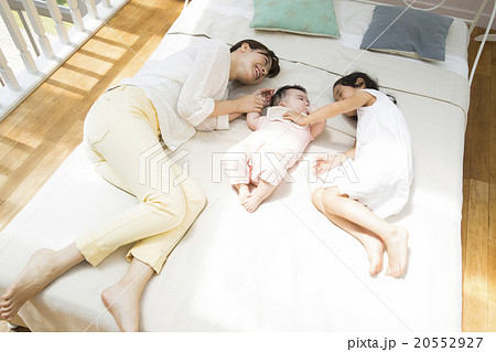 寝転ぶお母さんと赤ちゃんと女の子 寝転ぶお母さんと赤ちゃんと女の子 20552927