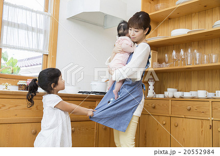 赤ちゃんを抱っこするお母さんとかまってほしい女の子 20552984