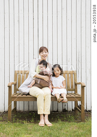 外を歩く赤ちゃんを抱っこしているお母さんと女の子 20553938