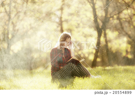 girl sits resting in a park on the fallen leaves 20554899