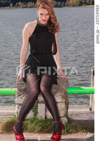 Young fashion woman sitting seductively on the lake 20558960