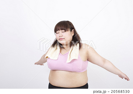 白い背景の前で目を閉じて深呼吸をしている太った若い女性 20568530