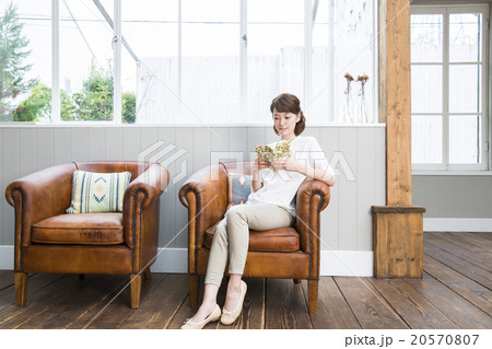 ソファで読書をする若い女性の写真素材
