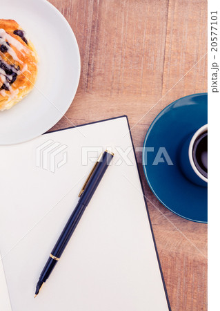 Pen on notepad by food and coffee at table Pen on notepad by food and coffee at table 20577101
