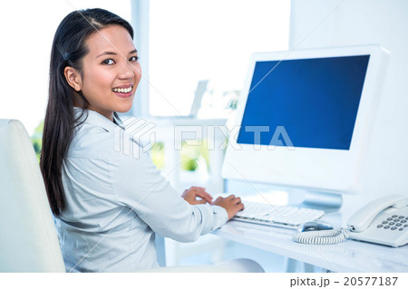 Smiling businesswoman working on computer 20577187