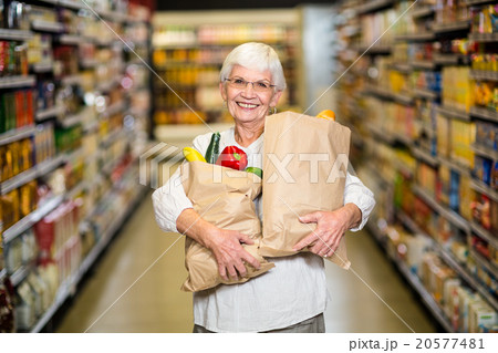 Portrait of smiling senior woman with grocery bags 20577481