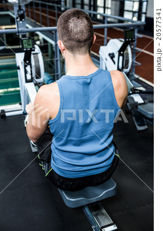 Muscular man using rowing machine Muscular man using rowing machine 20577541