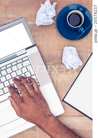 Stressed businessman using laptop by coffee at desk 20578237