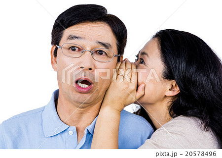 Woman whispering into partners ear 20578496