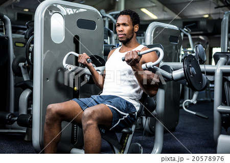 Serious muscular man using exercise machine Serious muscular man using exercise machine 20578976