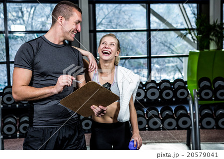 Fit woman discussing performance with trainer 20579041
