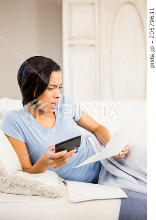 Surprised brunette counting bills Surprised brunette counting bills 20579631
