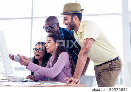Businesswomen explaining colleagues over computer Businesswomen explaining colleagues over computer 20579632