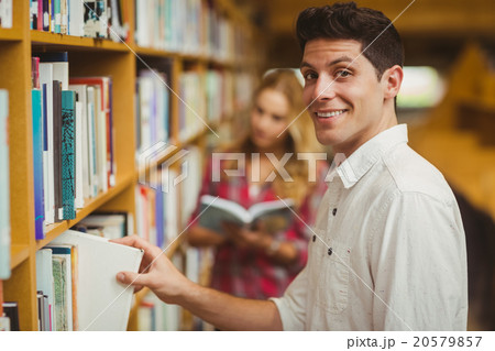 Smiling male student taking book Smiling male student taking book 20579857