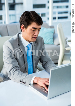 Concentrated businessman typing on computer 20580351