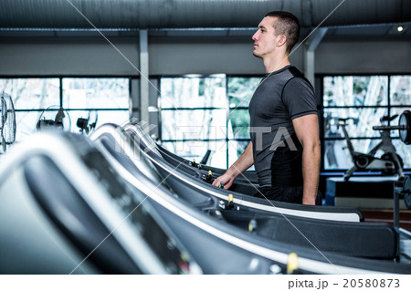 Concentrated muscular man using treadmill Concentrated muscular man using treadmill 20580873
