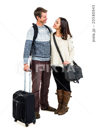 Full length of cheerful couple in warm clothing with luggag 20580945