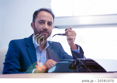 Portrait of hipster businessman working on typewriter 20581070
