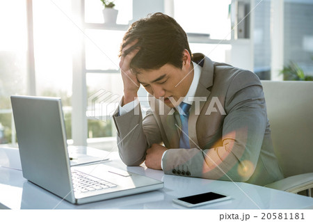 Tired businessman holding his head 20581181