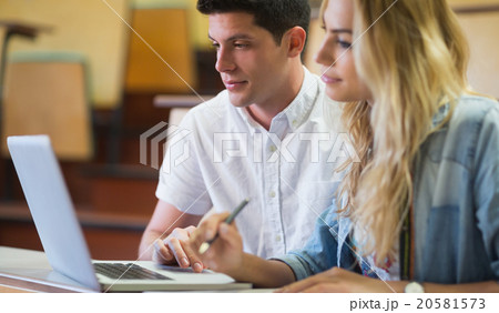 Smiling college students using laptop 20581573