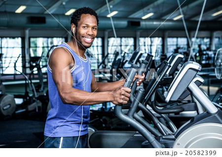 Smiling man working out with headphones on 20582399