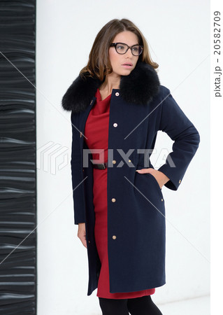 Girl in coat posing at studio Girl in coat posing at studio 20582709